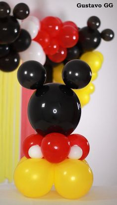 mickey mouse balloon sculpture in front of some balloons