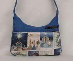 A great handmade Christian handbag. Medium  size handbag 8.5" x 12"  wide. It has  a large smart phone pocket along with 2 other  pockets in front.  A wide 12 inch zipper pocket along the whole back.  The strap is 33 inches long Wide 4 " bottom panels.  An upholstery  fabric  fully lined inside  that has 2 pockets, one is zippered for those personal items.   A light color lining with 2 pockets inside. The blue fabric is an upholstery weight  quality too.  This is a great fall/ winter bag. Can be washed too! Hand was the first time then with similar colors. 30 day guarantee.  See more sizes and designs on our website www.ritashandbags.com Blue Everyday Shoulder Bag With Side Pockets, Everyday Blue Shoulder Bag With Side Pockets, Blue Bags With Side Pockets For Daily Use, Denim Blue Bags With Cell Phone Pocket, Cotton Tote Shoulder Bag With Cell Phone Pocket, Winter Bags, Color Lines, Back Pocket, Smart Phone