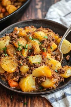 a close up of a plate of food with potatoes and meat on the side next to a fork