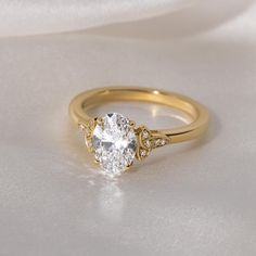 a gold engagement ring with an oval cut diamond