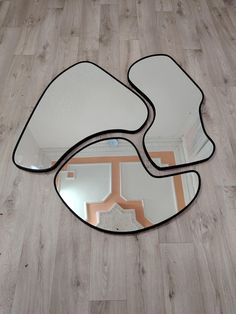 two mirrors sitting on top of a wooden floor