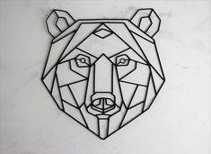 a bear head made out of geometric shapes on a white wall with marble flooring