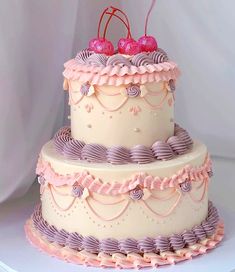 a three tiered cake with pink icing and cherries on the top layer