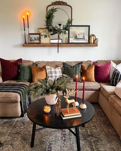 a living room filled with lots of furniture and candles on top of a coffee table