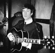 an old photo of a man holding a guitar