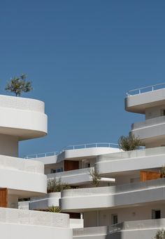 an apartment building with balconies and trees on top