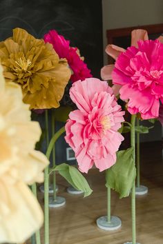 three vases with flowers in them on a table