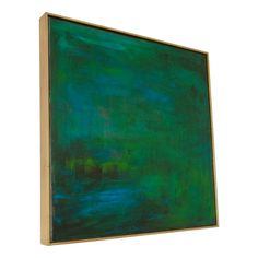 an abstract painting in green and blue on a white background with a wooden frame hanging from the wall