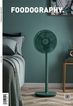 a green floor fan sitting on top of a bed