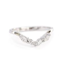 a white gold ring with three diamonds on the side and an arrow design in the middle