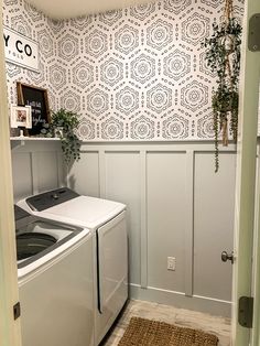 a washer and dryer in a small room with wallpaper on the walls