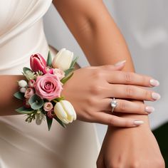 a close up of a person wearing a wedding ring and holding a bouquet of flowers