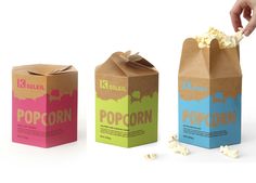 three boxes that have popcorn in them and one is being held by a person's hand