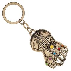 a keychain with a hand holding a coin on it's end and colorful stones in the middle