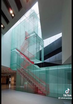 an empty room with stairs and glass walls