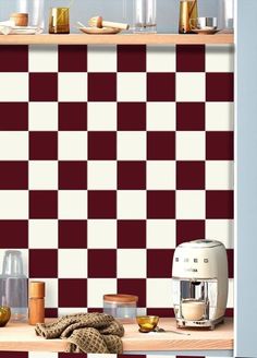 a kitchen with red and white checkerboard wallpaper, coffee maker on the counter