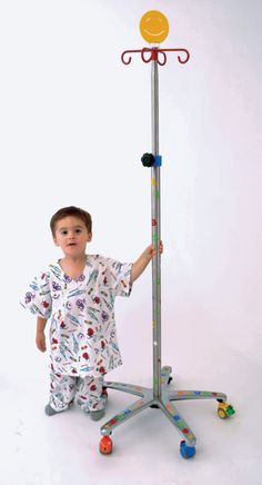 a little boy standing next to a tall metal pole