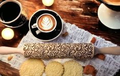 some cookies are on a table next to a cup of coffee and a rolling pin