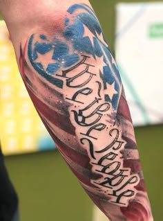 a man's arm with an american flag and lettering on it