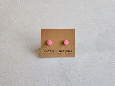 small pink and white polka dot studs on brown card with text catalilla designs