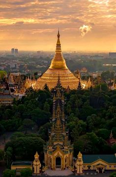 an aerial view of the golden pagodas and surrounding buildings at sunset, in thailand