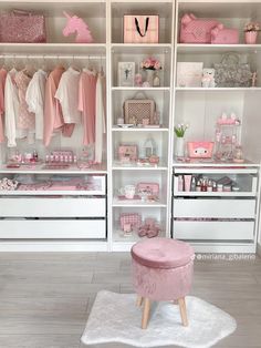 a white closet filled with lots of pink and white items, including baby's clothes