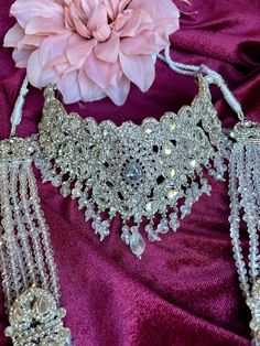 This traditional set comes as a full bridal piece with choker and long necklace along with earrings, tikka, passa. The set comes in two colors with silver and white beads and gold and red beads. Silver Kundan Sets For Festive Occasions, Silver Kundan Sets For Festive Season, Festive Silver Kundan Set, Festive Kundan Silver Sets, Silver Kundan Lehenga For Wedding, White Kundan Jewelry For Traditional Ceremonies, Traditional Silver Hand Set, Traditional Silver Hand-set, White Traditional Choker For Ceremonial Occasions