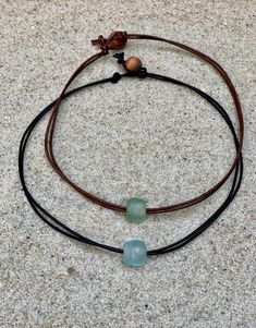 A new twist on everyone's favorite necklace! Let your inner beach girl shine when you wear this leather choker. An African glass bead bead floats freely along doubled up leather cords. A shorter length is cute as a choker, peeking above a tee shirt. A longer length can be layered wit another favorite necklace. A simple loop and wooden bead closure makes for easy on and off. African glass beads are made from recycled glass in Ghana. Each is handmade and unique. The necklaces in the pictures are f Handmade Necklaces Diy, Boho Necklace Diy, Beach Necklace Boho, Boho Leather Necklace, Shirt Jewelry, Earthy Necklace, Beach Necklace, Estilo Hippie, Beach Necklaces