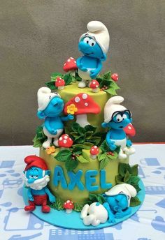 there is a cake made to look like the smurfs on top of it