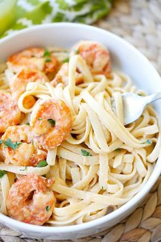 a white bowl filled with pasta and shrimp