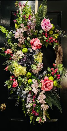 a wreath with flowers and greenery on the front door