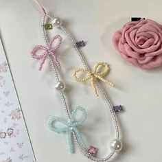 three different colored bows and pearls on a table