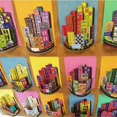 colorful cityscapes are displayed on the wall in this art project, which is made out of colored paper