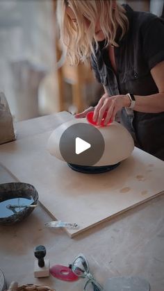 a woman is making something on a table