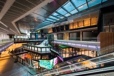 the inside of an airport terminal with multiple escalators