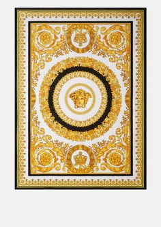 an intricate gold and black scarf with a lion head on the center, surrounded by ornate swirls