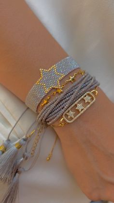 a close up of a person's arm wearing bracelets with stars on them