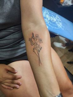 a woman's arm with a flower tattoo on the left side of her body