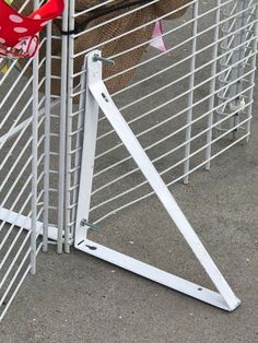 a pair of red shoes hanging on the side of a metal fence next to a basket