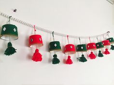 a group of bells hanging from a line with tassels attached to the strings