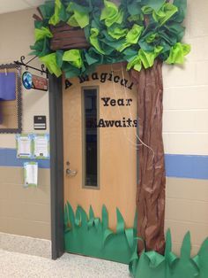 an image of a classroom door decorated with paper trees and leaves on the front wall