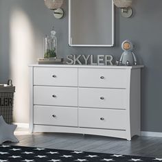 a white dresser and mirror in a child's room