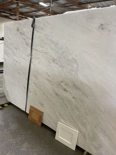 two white marble slabs sitting in a warehouse