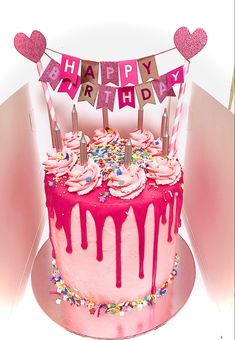 a birthday cake with pink icing and sprinkles