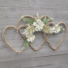 two heart shaped wooden wall hangings with flowers and leaves on the top of them