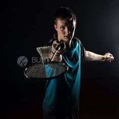 a young man holding a tennis racket and ball