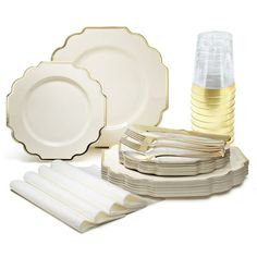 a set of white dinnerware with gold trimmings