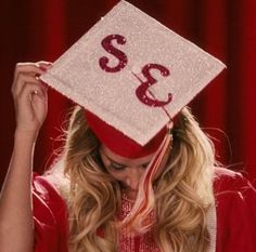 a woman wearing a red graduation cap with the number 32 on it's side