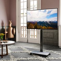 a flat screen tv sitting on top of a wooden stand in front of a window