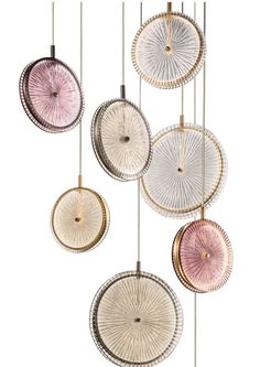 an assortment of circular lights hanging from the ceiling in various shades of pink, white and gold